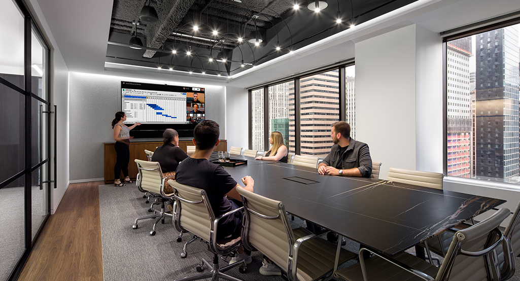 people collaborating in boardroom with conference call