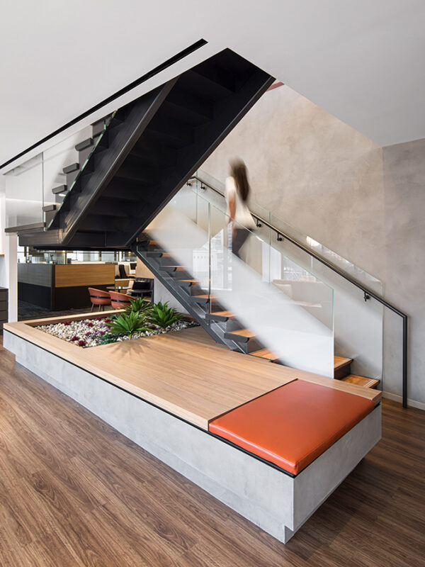 woman walking up staircase and view of open plan office with partitions