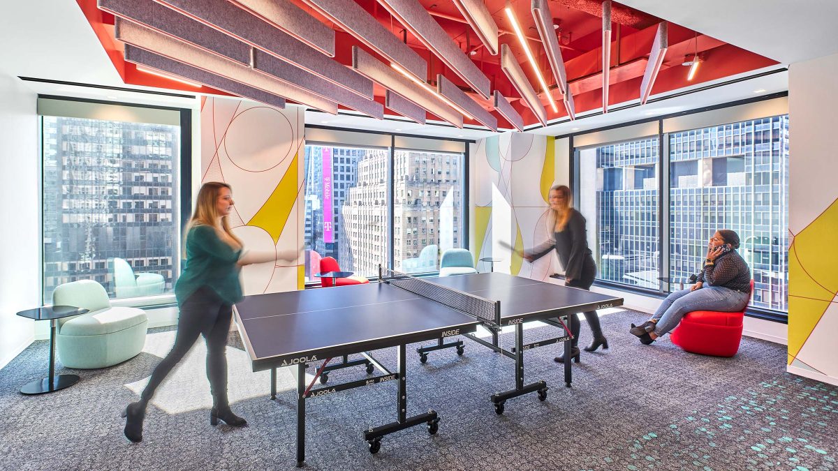 Interactive workplace experience featuring a break area for employees with a ping pong table and colourful artwork and lighting.