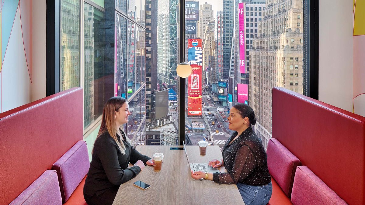 A hospitality-inspired booth design for Adobe in New York City overlooking Times Square.