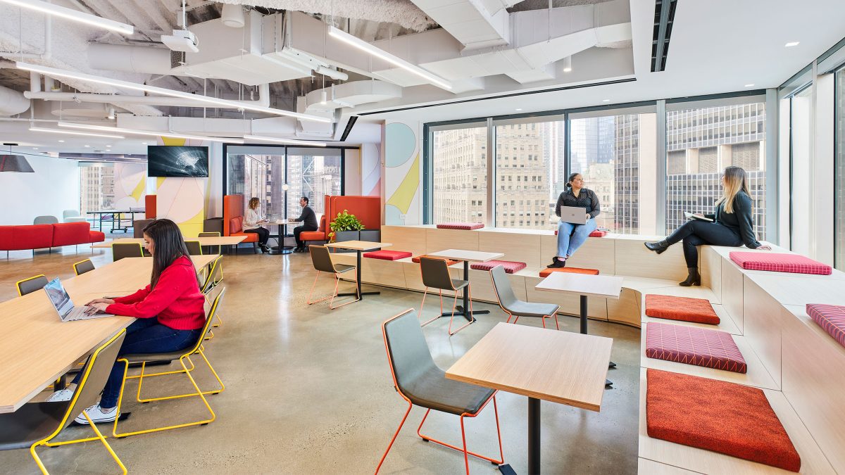 Central meeting and collaboration area at Adobe in New York City featuring tiered seating, long tables and a comfortable atmosphere conducive to work.