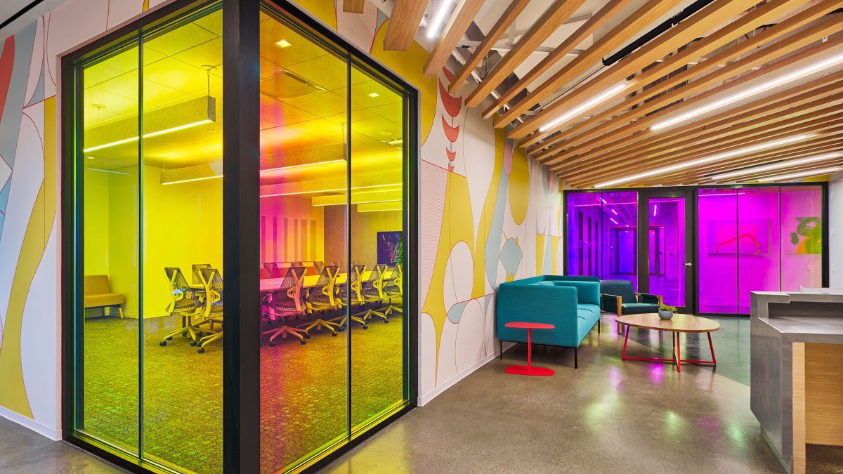 Using colour as a tool to impact employee behaviour and instil the workplace with an upbeat atmosphere, this area features tinted glass walls and vibrant environmental graphics.