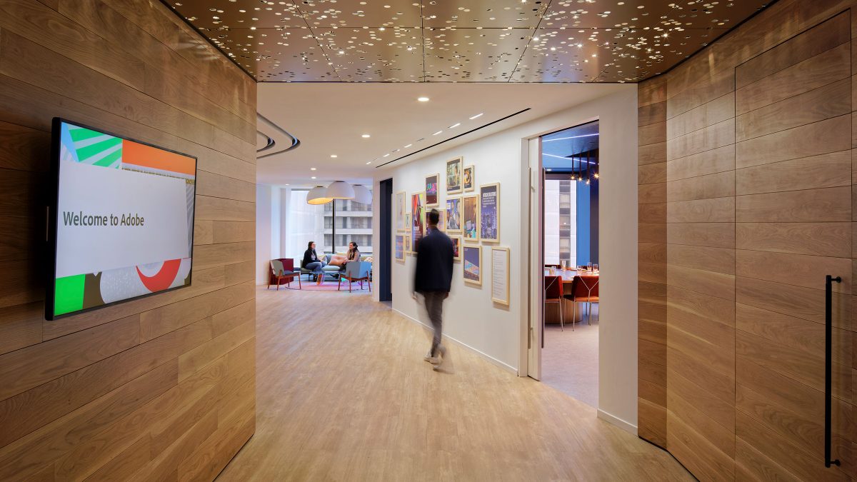 Corridor at Adobe office in New York featuring warm wooden panelling and custom lighting.