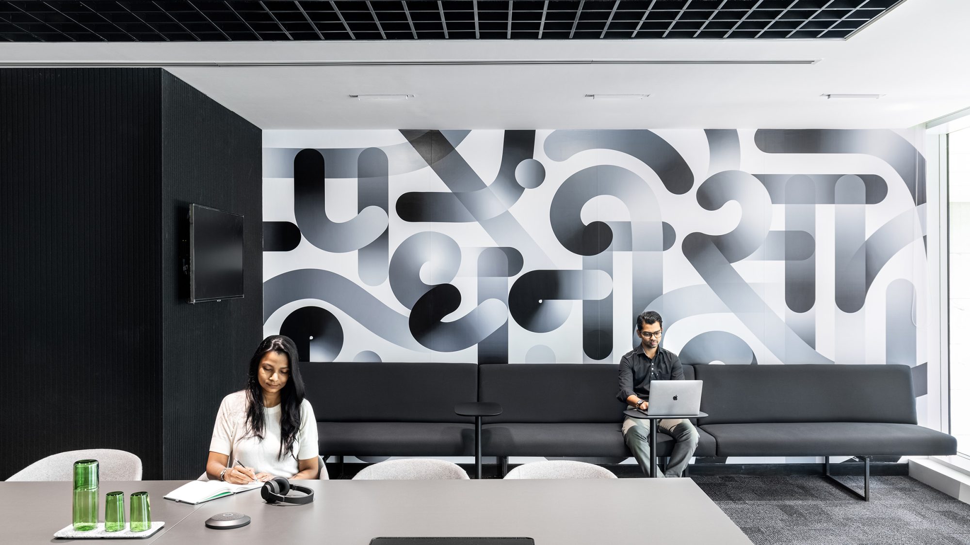 people sitting in front of monochromatic graphic wall