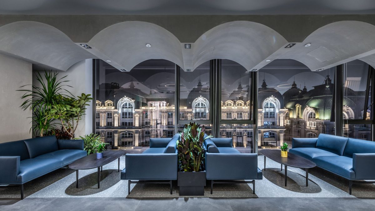 Modern office waiting area with blue leather chairs and plants