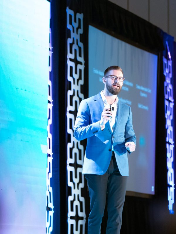 Grant Christofely on stage presenting at WorkSpaces 2022 event in Palm Springs, California.
