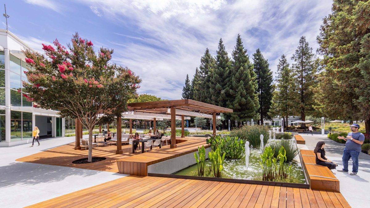 Outdoor office campus design featuring multiple seating areas, shaded workspaces and water features.