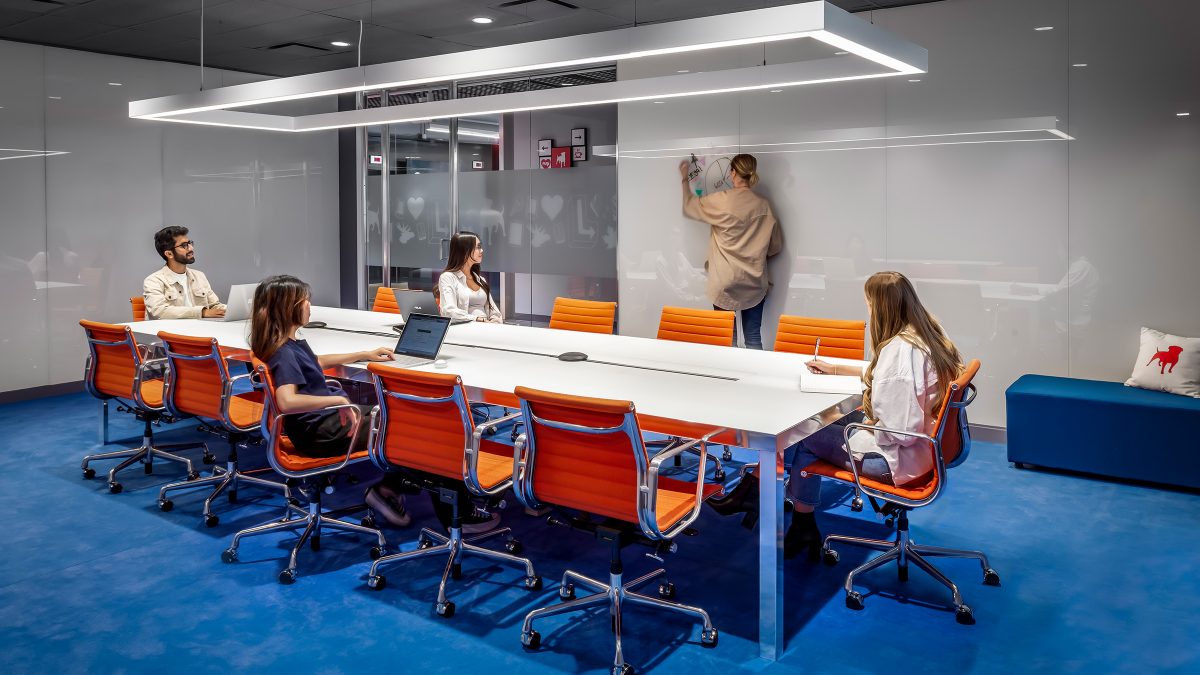 A colourful boardroom to provide stimulation for innovating teams and is set up with acoustic noise control, whiteboards for brainstorming and planning and connective technology.