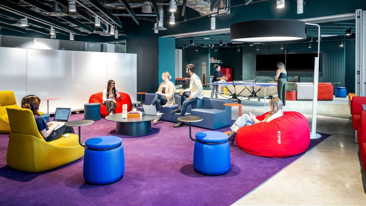 Large team collaboration area featuring moveable furniture to support various meeting styles within different groups and teams and a ping pong table activity space.