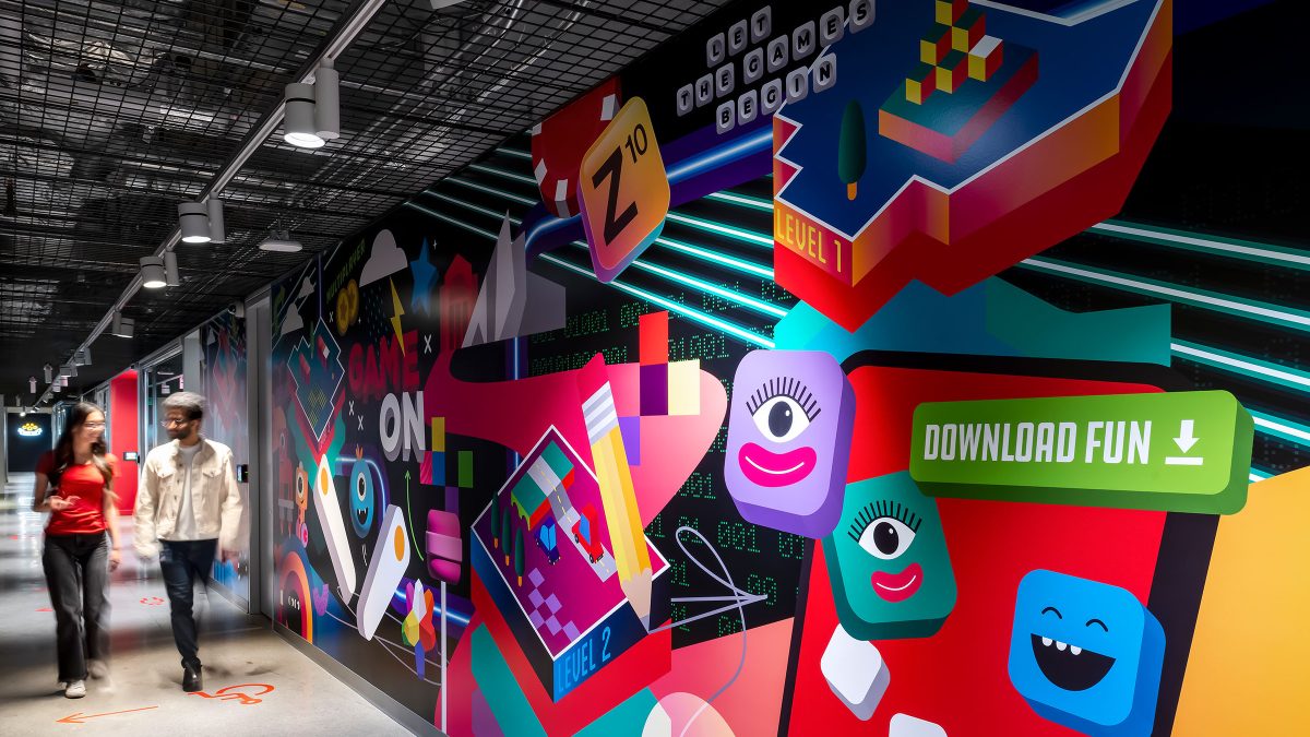 A colourful corridor at Zynga’s office in Toronto featuring branded graphics and wayfinding for employees and visitors.
