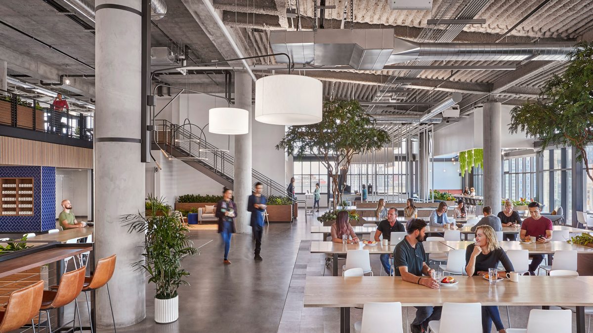 M Moser’s interior office design for a San Francisco client features a large servery-style kitchen with large communal tables.