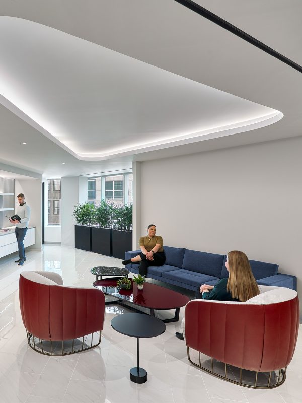 Unique workplace zone featuring a small library and comfortable chairs for employee interaction and rest throughout their workday.