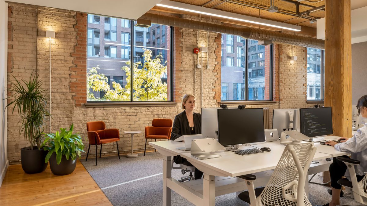 Ergonomic office chairs and sit-to-stand desks at Faire’s Toronto office provided by M Moser architecture and design firm. 