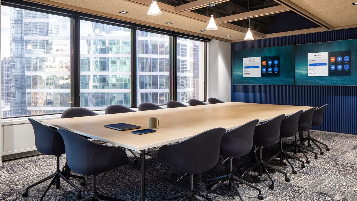 Workplace interior design for headquarters in Vancouver featuring a boardroom with a long table, technology for presentations and remote workers, ergonomic furniture and natural light.