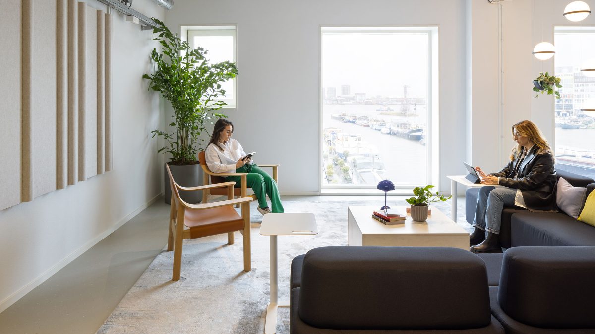 Calming office interior lounge space with windows looking to Amsterdam dock.