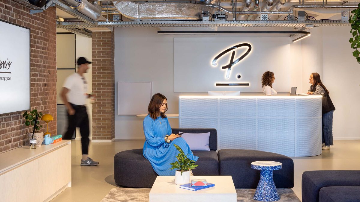 Office interior reception space with woman sitting in lounge