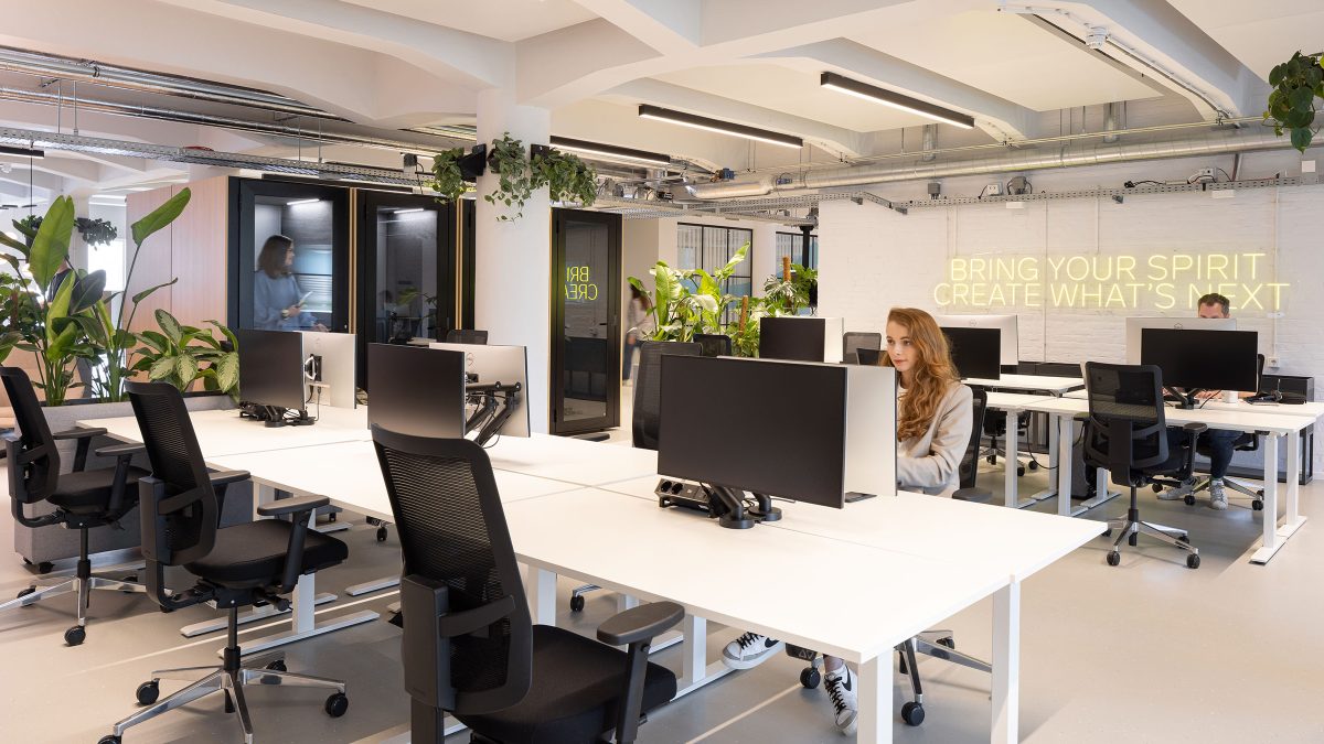 Open plan workstations in office with focus booths for calls.
