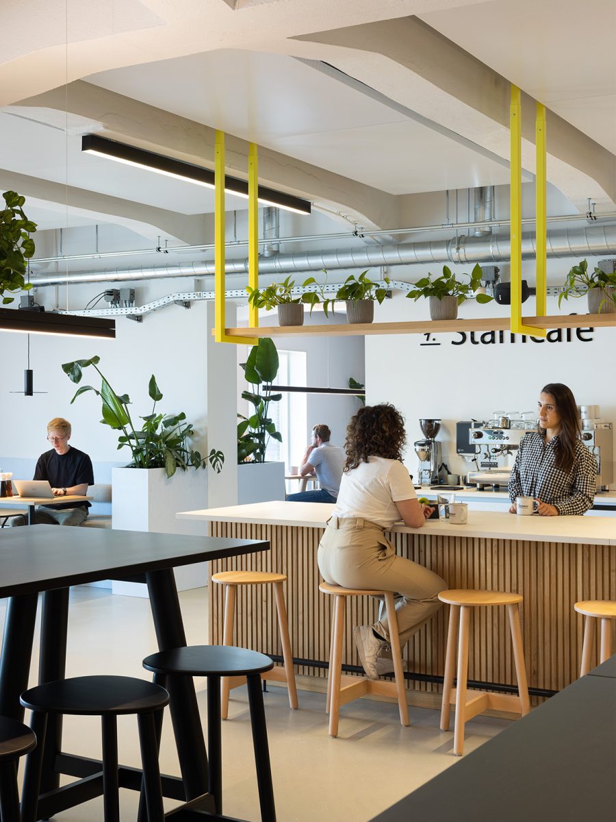 People relaxing in communal cafe space in office interior 