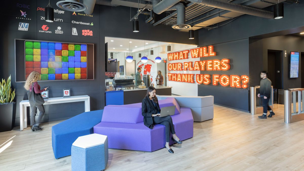 Interior design for gaming company Zynga at their San Mateo headquarters featuring branded gaming elements and colourful artwork in a casual employee social area. 