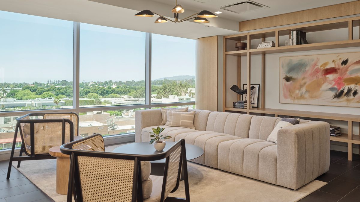 Hospitality-driven design for a corporate LA office by M Moser Associates featuring comfortable, luxury furniture, natural rattan chairs and lots of natural light in a collaboration space.