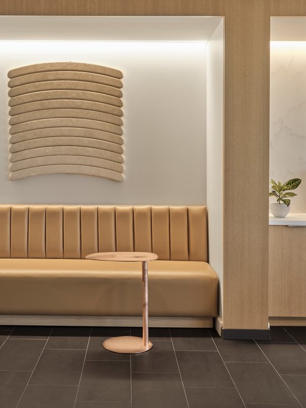 High-end interior design for a corporate office featuring a warming colour palette, bench seating and artwork.
