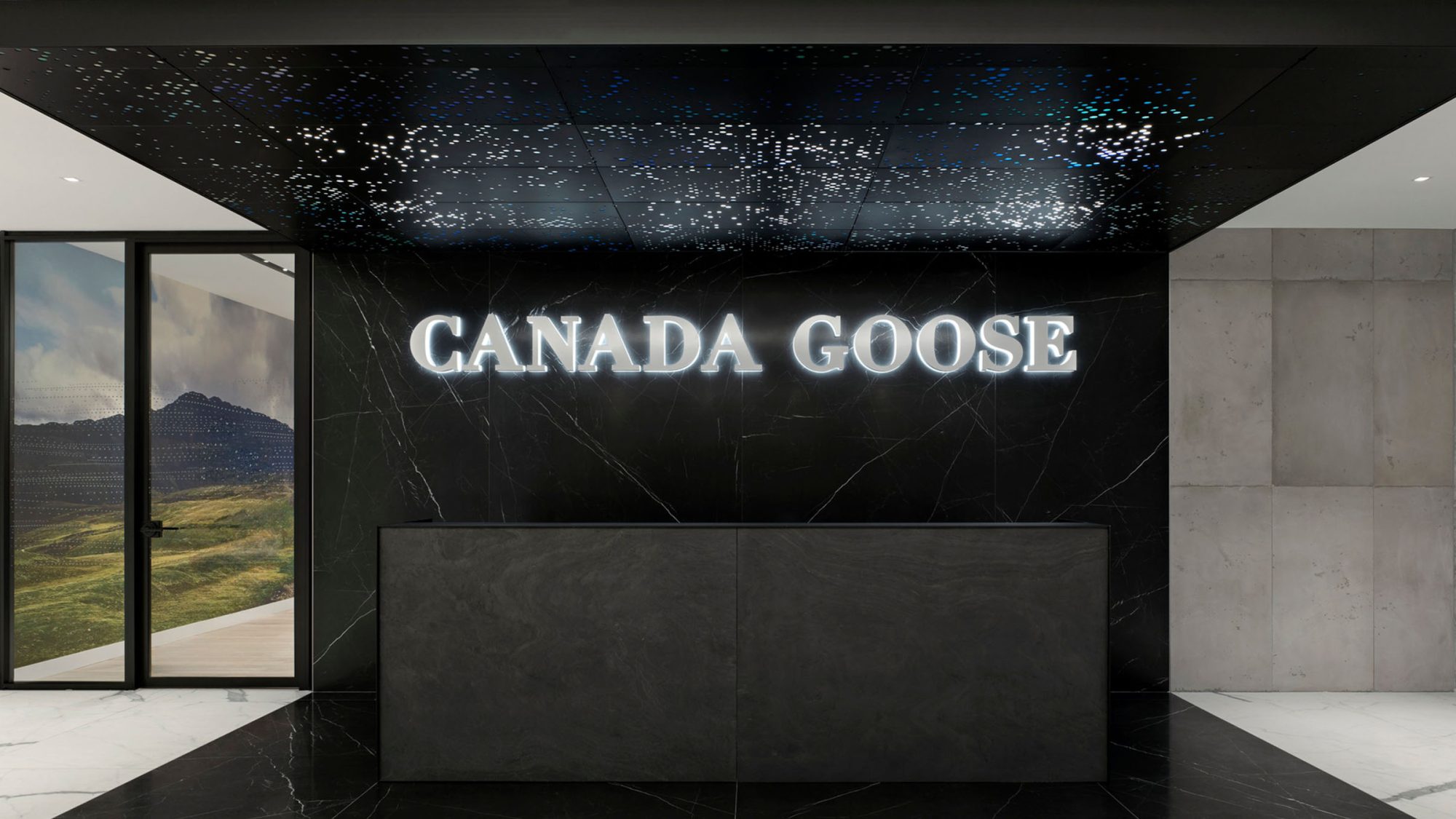 Interior design project by M Moser for Canada Goose in Toronto featuring a branded reception area and Northern Lights installation.