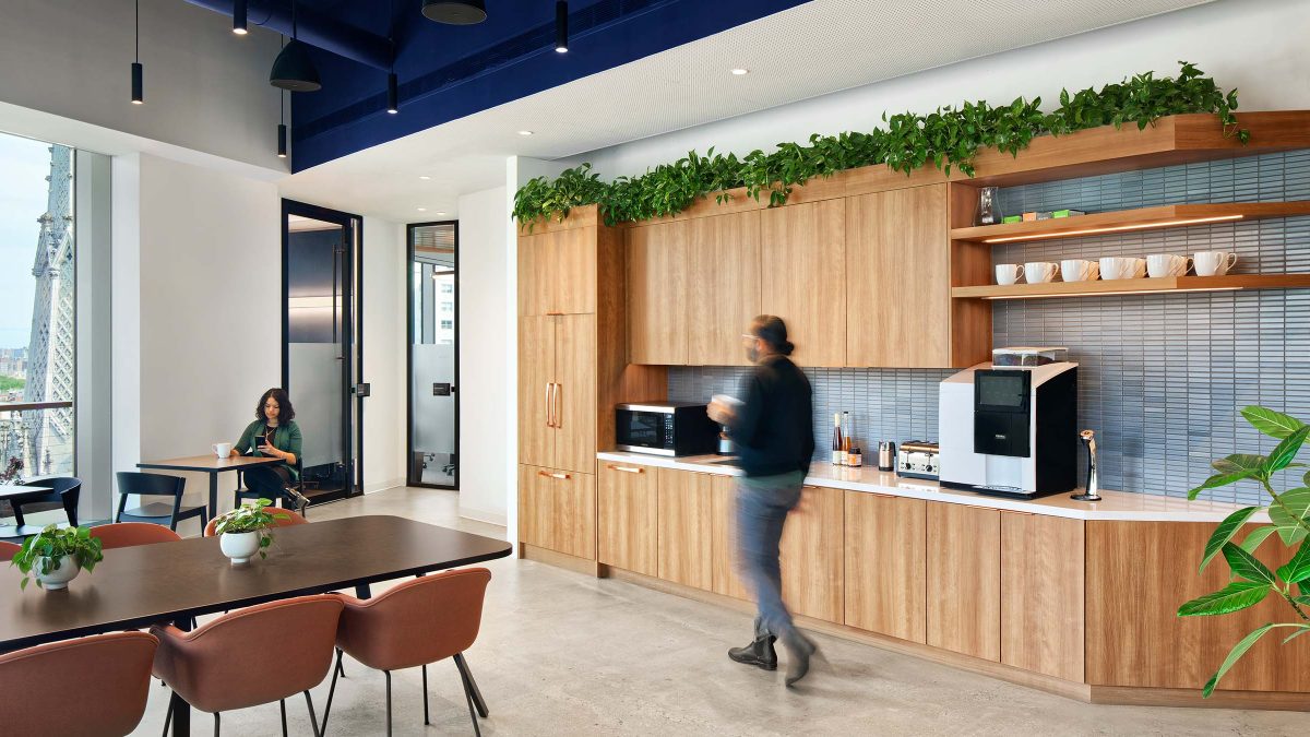 Kitchen design by M Moser featuring plants, natural wood finishes, and lots of hospitality-driven style and seating options. 