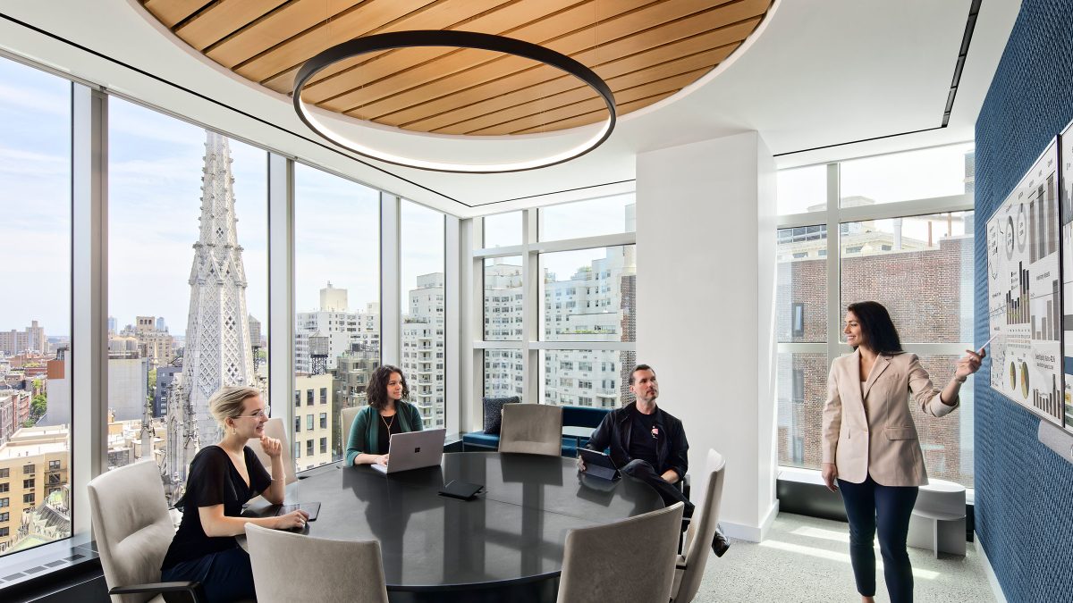 Meeting room design featuring acoustic interventions, a round table for employees and technology.