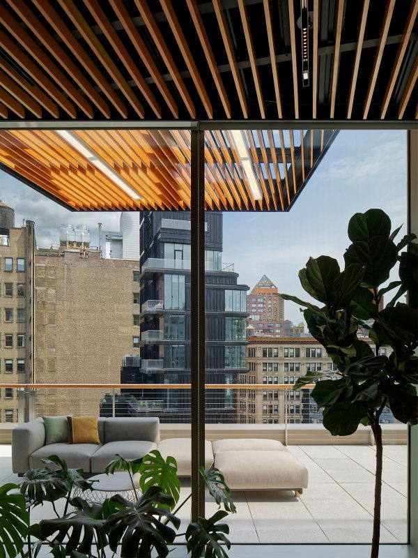 An indoor-outdoor experience featuring expansive floor-to-ceiling windows and an expansive view of New York City.