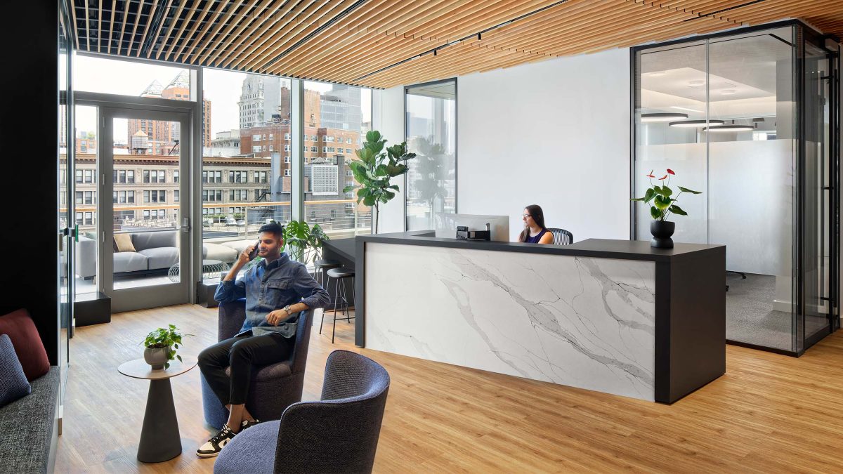 Inviting reception area design by M Moser’s interior design team featuring timeless aesthetics, natural woods, marble and comfortable furniture for guests.