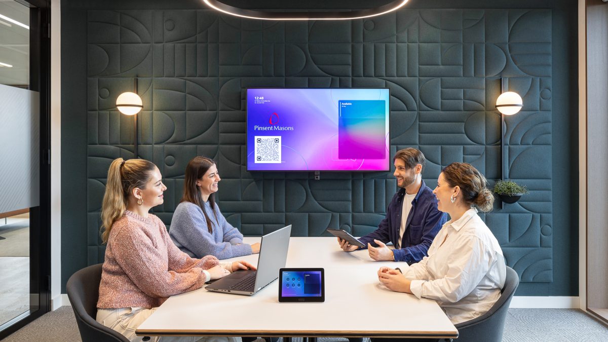 a team collaborating in a small meeting room at pinsent masons' amserdam office