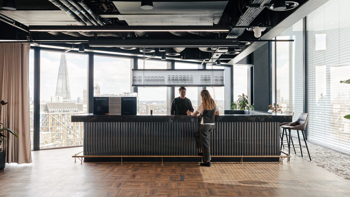 two-people-stood-at-club-lounge-bar-at-wipro-london-office