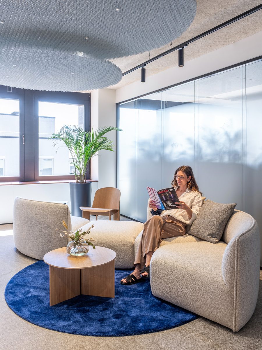 person-sat-reading-in-lounge-setting-at-icg-design-and-build-luxembourg-office